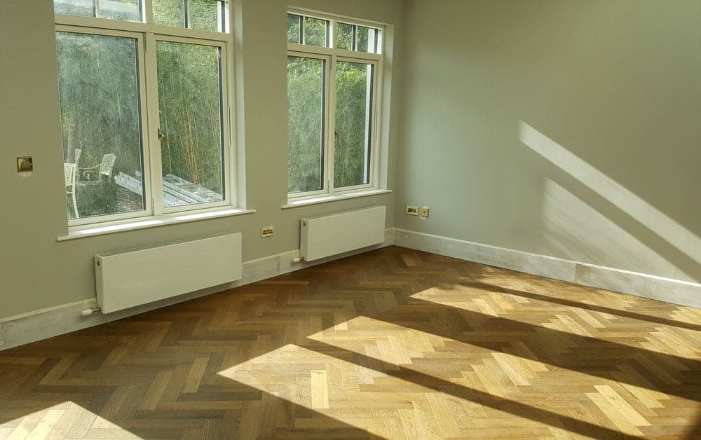 Sunlit garden room with a herringbone oak floor