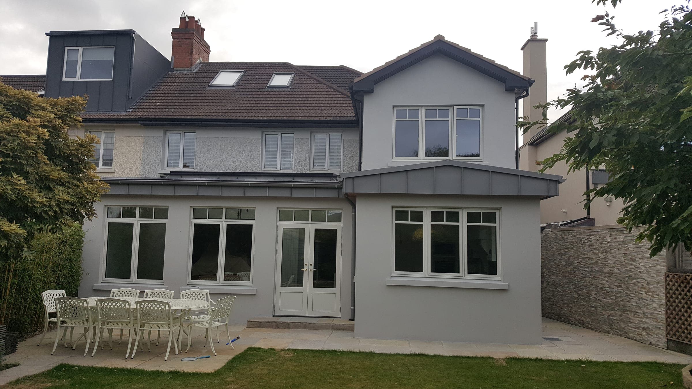 Two-storey rear extension with a zinc-clad canopy and garden patio